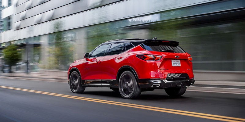 Red 2022 Chevrolet Blazer driving in city in two-way street