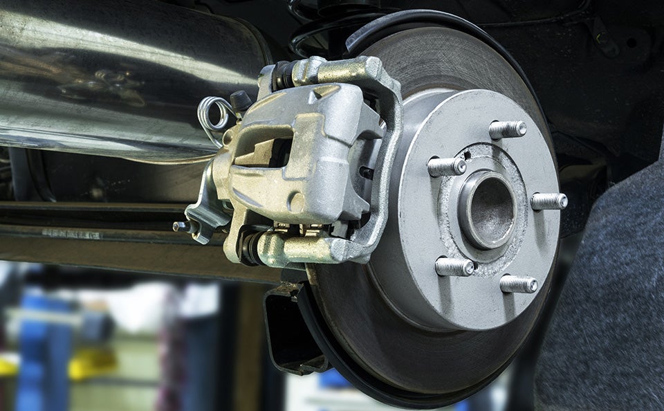 A technician installing a brake caliper.